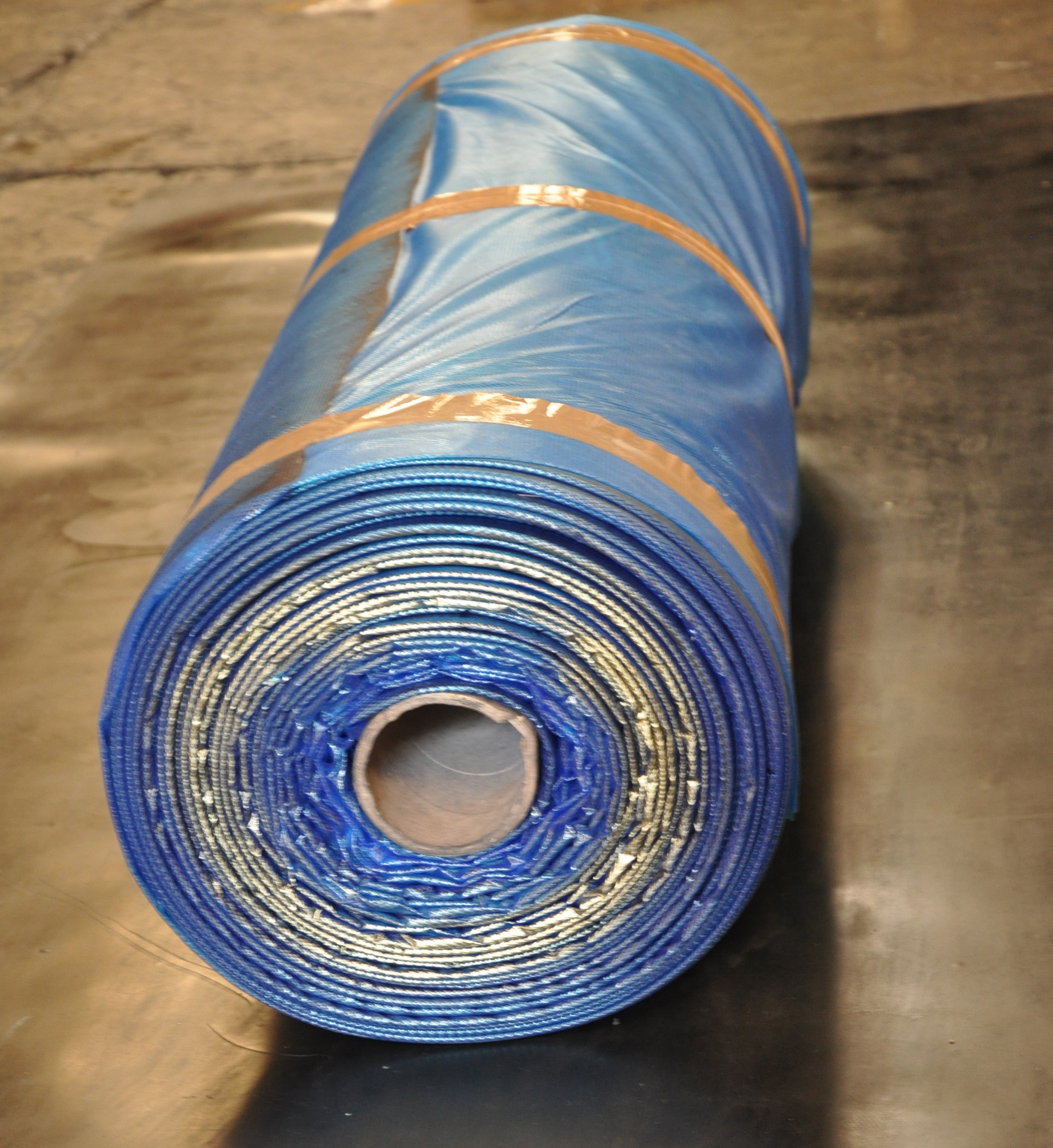 Blue uncured crude rubber on roller during rubber contract manufacturing process